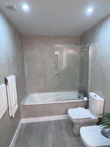 a bathroom with a bath tub and a toilet at Sesimbra Oasis Apartment in Sesimbra