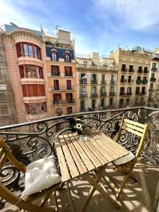 - une table et des chaises en bois sur un balcon avec des bâtiments dans l'établissement Barcelona Central Apartments, à Barcelone