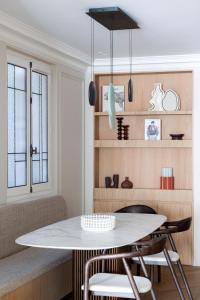 uma sala de jantar com uma mesa branca e cadeiras em HIGHSTAY - Luxury Serviced Apartments - Centre Pompidou em Paris