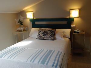 a bedroom with a large white bed with a green headboard at Hotel Migal in Cue