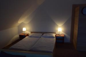 a bedroom with two beds and two lamps on tables at Apartament Czos Kominek Premium in Mrągowo