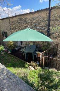 a green umbrella in a yard with a table at Corte 40 Rooms in Negrar