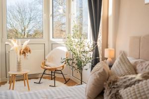 a living room with a bed and a chair and a window at Dein Ruhepol an der Nordseeküste mit Sauna in Cappel-Neufeld