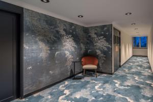 mural de pared en un pasillo con silla en DoubleTree by Hilton Paris Bougival, en Bougival