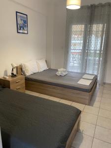 a bedroom with two beds and a window at Jenny's Holiday Villas in Polychrono