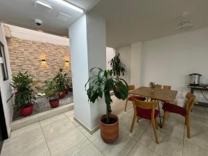 a dining room with a table and a potted plant at Hotel Mar Inn Cali in Cali