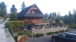 a log cabin with a car parked in front of it at Chalupa Lenka in Vysoké Tatry