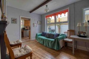 sala de estar con sofá verde y cocina en Large character home, hot tub, beach 5 min walk, en Gorleston-on-Sea