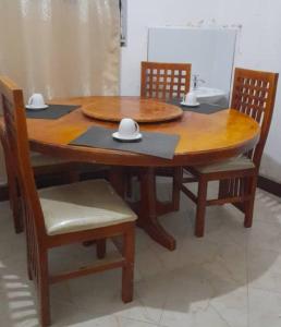 drewniany stół z dwoma krzesłami i stół z dwoma kapeluszami w obiekcie Bugara Homestay w mieście Kisoro