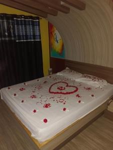 a bed with red roses on it with a cake at MR Resort Room type in Ooty