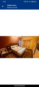 een hotelkamer met 2 bedden en een televisie bij MR Resort Room type in Ooty