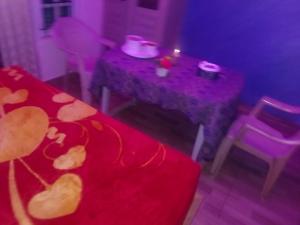 a purple room with a table and chairs with a red blanket at MR Resort Room type in Ooty