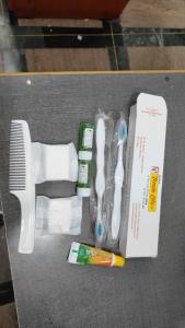 un ensemble de brosses à dents et d'un peigne et de dentifrice dans l'établissement MR Resort Room type, à Ooty