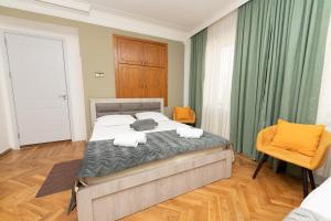 a bedroom with a bed and two orange chairs at Anna's Guest House in Gori