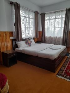 1 dormitorio con 1 cama y 2 ventanas en Yalung Homestay, en Darjeeling