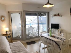 een woonkamer met een tafel en stoelen en een balkon bij Ocealine, Proche plages, Vue Salines, U71 in Carnac