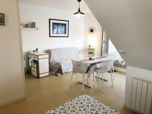een kamer met een tafel en stoelen en een bed bij Ocealine, Proche plages, Vue Salines, U71 in Carnac