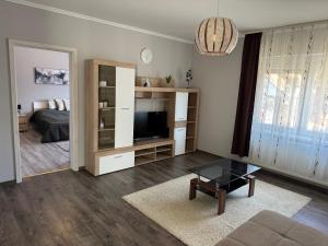uma sala de estar com um sofá e uma televisão em Zsike vendégház em Tolna
