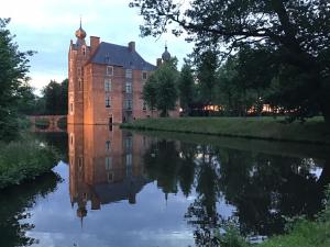 a castle reflected in the water of a river at Dennenhuis in Vaassen