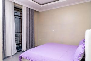 een slaapkamer met een bed en een raam bij Kigali Homes Villa in Kigali