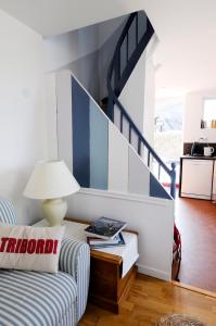 een woonkamer met een bank en een trap bij Maison cosy vue mer à 50m de la plage in Étretat