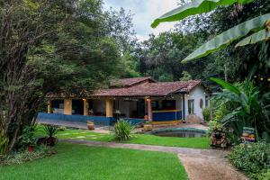una casa con piscina en un patio en Pousada das Brumas, en Brumadinho