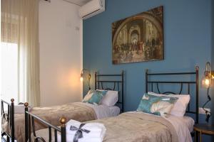 Duas camas num quarto com paredes azuis em Casa Graziosa em Ercolano