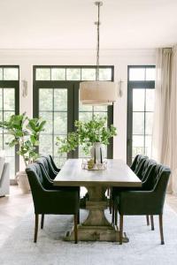 a dining room with a table and green chairs at Villa am Wald in Meckenheim