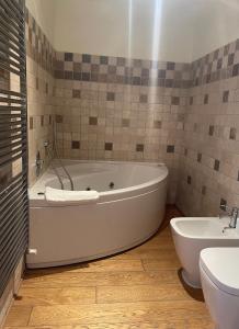 a white bath tub in a bathroom with a toilet at La Quintessenza del Borgo in Varzi