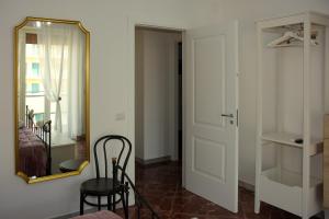 um quarto com um espelho, uma cadeira e uma porta em Casa Graziosa em Ercolano