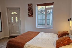 a bedroom with a bed and a window and a door at Forest view cottage in Nottingham