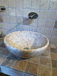 a wooden bowl sitting on a tiled floor in a bathroom at La Quintessenza del Borgo in Varzi