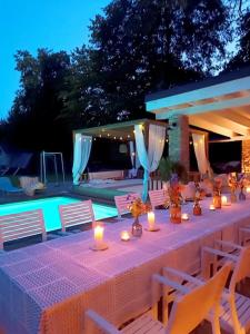 a long table with candles on it next to a pool at Villa am Wald in Meckenheim