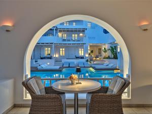 a room with a table and chairs in front of a house at Stelia Mare Boutique Hotel in Naousa