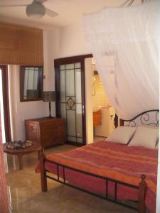 a bedroom with a bed and a table in it at Belle villa , pieds dans l'eau avec piscine in Terre Rouge