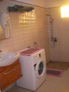 a washing machine in a bathroom next to a sink at Belle villa , pieds dans l'eau avec piscine in Terre Rouge