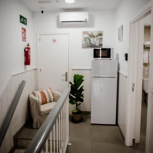a stairway with a white refrigerator in a room at Pensión Mastil 16 in Málaga
