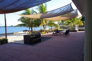un patio con sedie e tavoli sulla spiaggia di Belle villa , pieds dans l'eau avec piscine a Terre Rouge