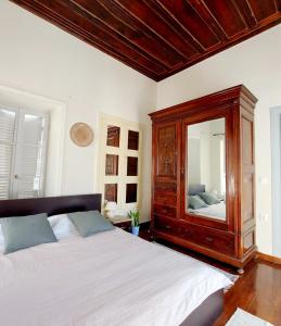 een slaapkamer met een groot bed en een grote spiegel bij Christina's Stone House Apartment in Hydra