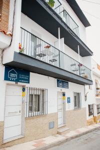 een wit gebouw met een balkon erboven bij Pensión Mastil 16 in Málaga