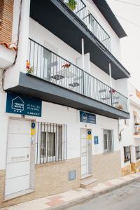 a white building with a balcony on top of it at Apartamentos Turisticos Mastil 16 in Málaga