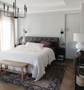 Un dormitorio con una gran cama blanca y una lámpara de araña. en Villa am Wald en Meckenheim
