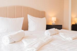 a white bed with white sheets and pillows at Dein Ruhepol an der Nordseeküste mit Sauna in Cappel-Neufeld