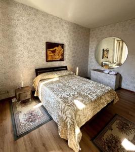ein Schlafzimmer mit einem Bett und einem großen Spiegel in der Unterkunft Appartamento nel cuore di Asti in Asti