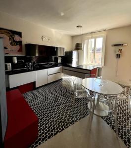 eine Küche mit einem weißen Tisch, einem Tisch und Stühlen in der Unterkunft Appartamento nel cuore di Asti in Asti