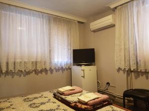 um quarto com uma cama, um frigorífico e uma janela em Къща за гости Жорж em Bankya