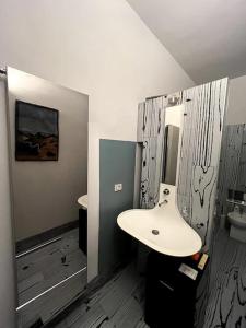 ein Bad mit einem Waschbecken und einem Spiegel in der Unterkunft Appartamento nel cuore di Asti in Asti
