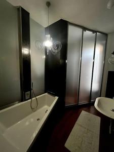 ein Badezimmer mit einer Badewanne und einem Waschbecken in der Unterkunft Appartamento nel cuore di Asti in Asti