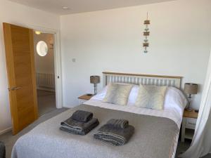 1 dormitorio con 1 cama con 2 toallas en Beachside, Torcross, between the Sea and the Ley en Torcross