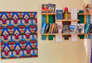 a room with two shelves and books on a wall at Maasai House - Arusha in Sokon
